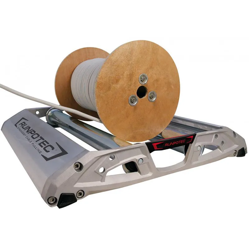 Image illustrant l'efficacité du dérouleur de câble ALUROL de RUNPOTEC en utilisation avec un touret à câble posé dessus. Fabriqué en aluminium moulé sous pression, léger et solide, ce dérouleur est équipé de galets de support robustes et réglables, parfaitement adaptés aux charges lourdes. Les galets avec axes à ressort s'ajustent facilement aux différentes tailles de tourets, tandis que les roulements fermés protègent contre la saleté et la corrosion, garantissant un fonctionnement fluide et sans entretien. Les pieds en plastique de haute qualité offrent un support stable et antidérapant, préservant les revêtements de sol.