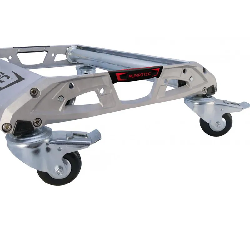 Image du dérouleur de câble ALUROL de RUNPOTEC monté sur des roulettes en non utilisation. Ce dispositif léger et solide, fabriqué en aluminium moulé sous pression, est équipé de galets de support robustes et réglables, adaptés aux charges lourdes. Les roulements fermés des galets protègent contre la saleté et la corrosion, garantissant un fonctionnement sans entretien. Les roulettes pivotantes offrent une maniabilité accrue, facilitant le transport tout en préservant les revêtements de sol.